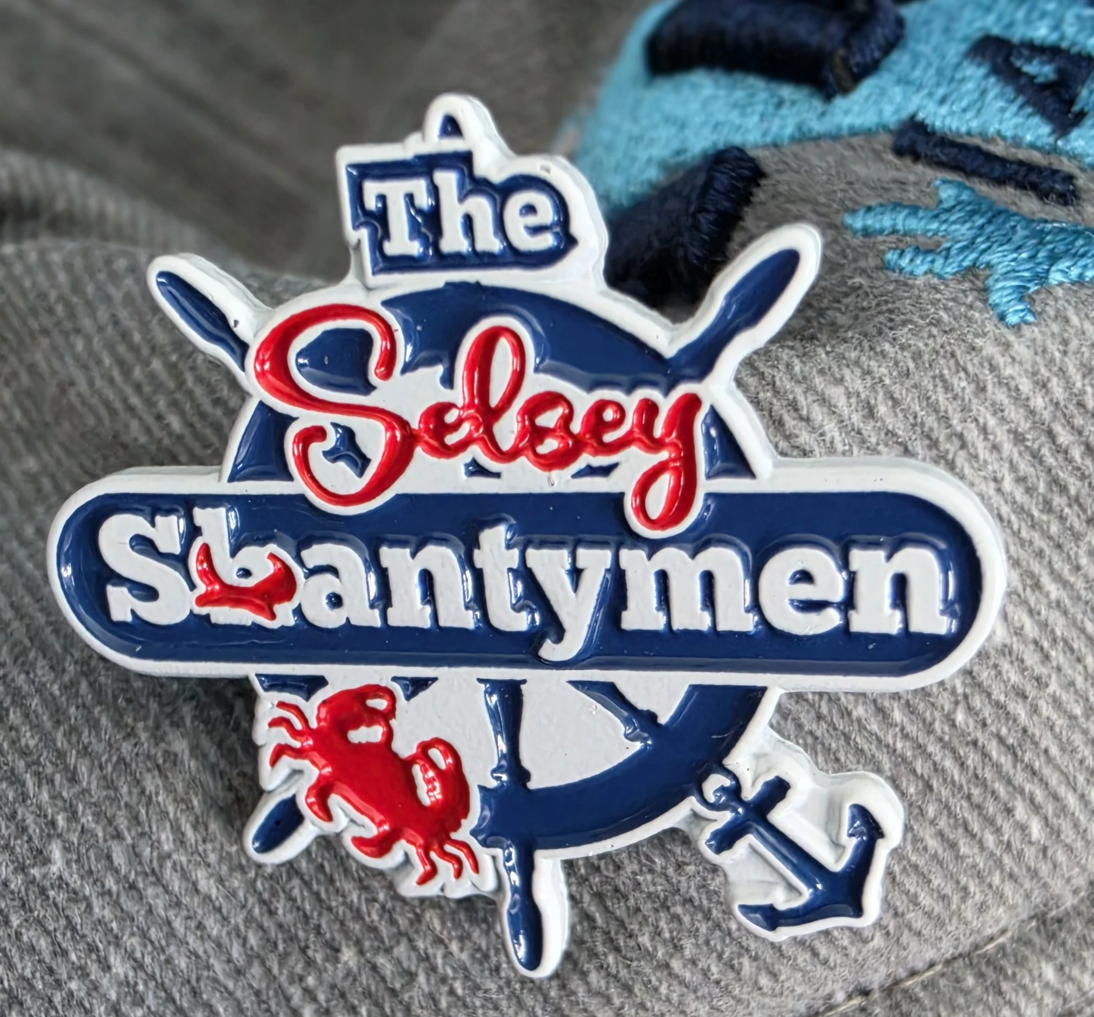 Pin badge showing the group logo